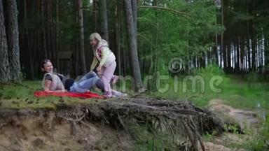 一位孕妇躺在树林里的<strong>红毯</strong>子上，享受大自然。